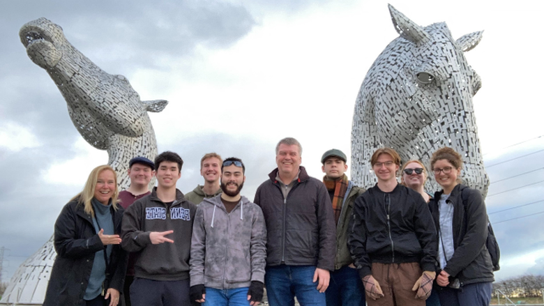 A group of eight students and two faculty advisors standing in front of  “The Kelpies”