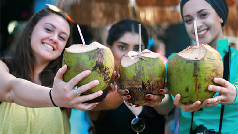 A group of students holding coconut drinks